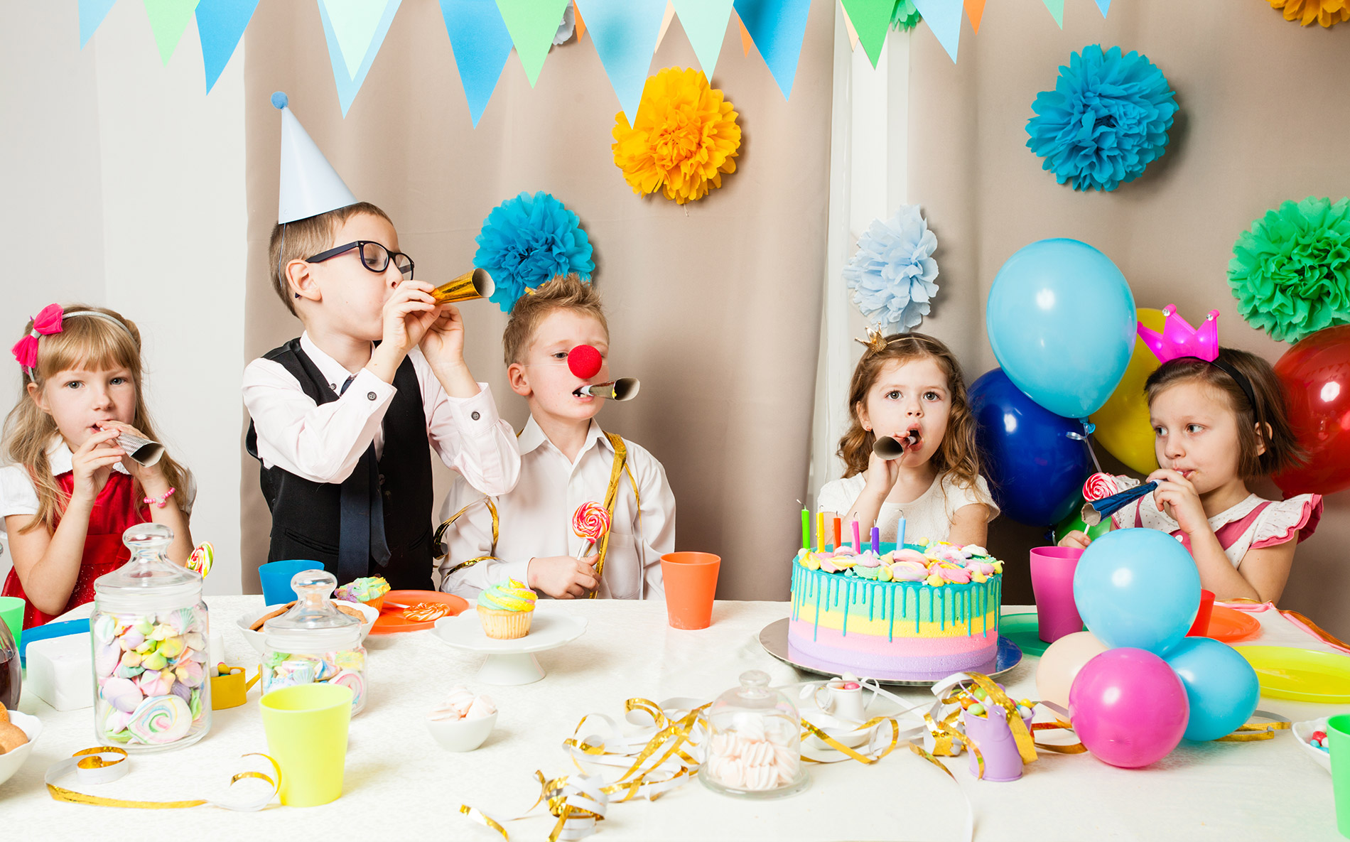 Children having a party in front of a birthday cake